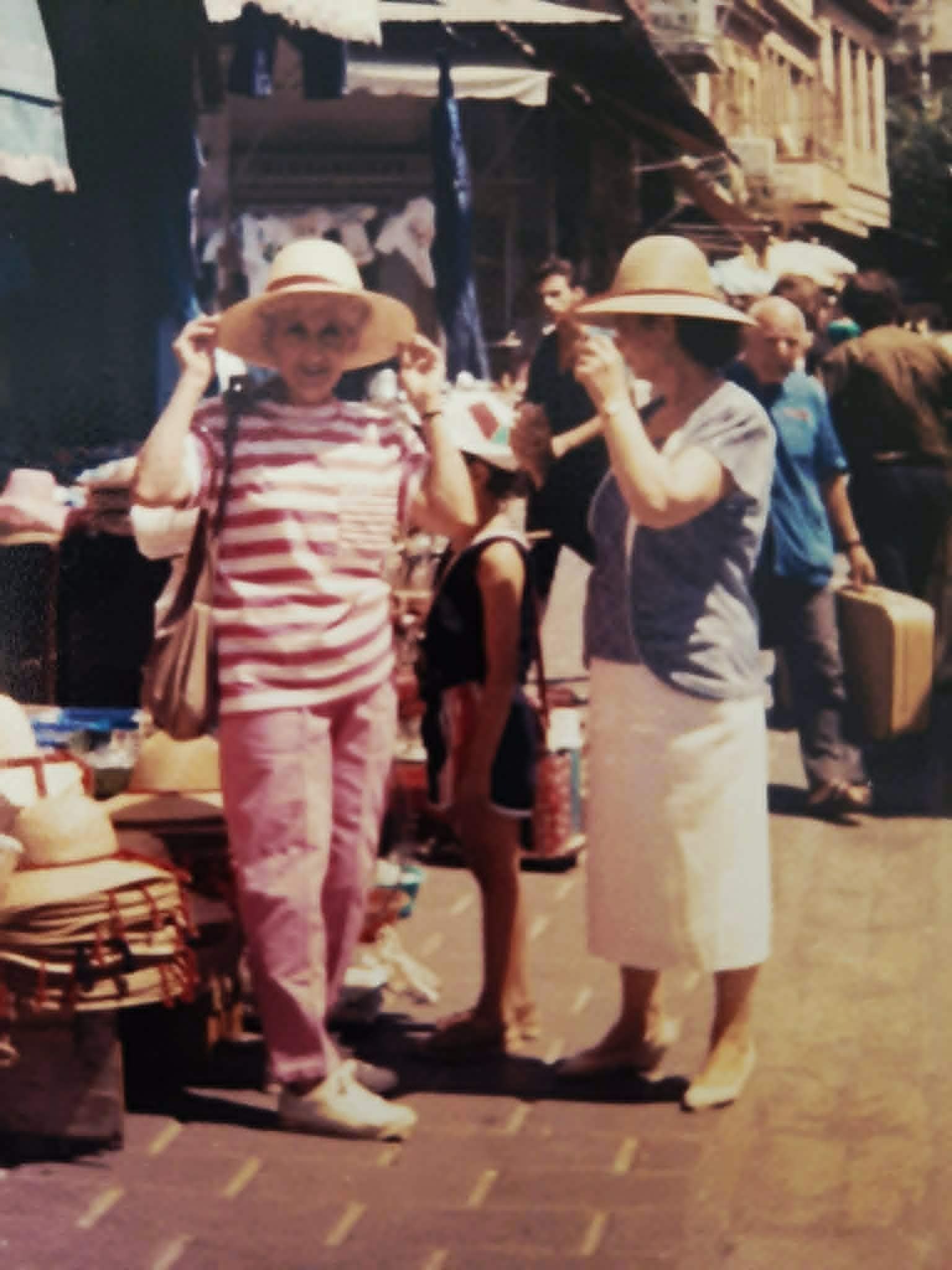 Lydia and her Greek son-in-law's mother try on hats at the Greek flea market.