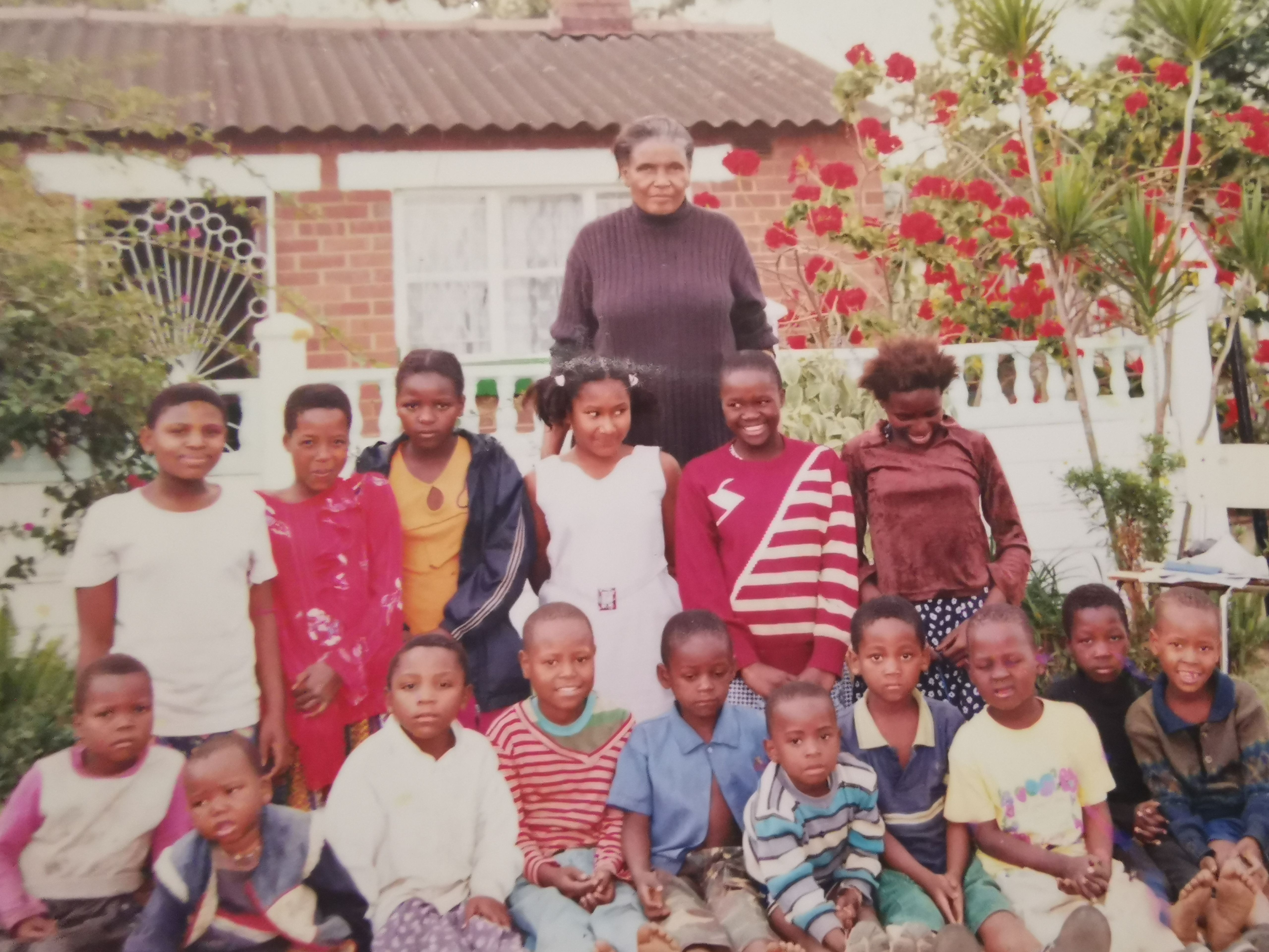 Gogo outside her house in PMB with the children from the children's church she started in her community.